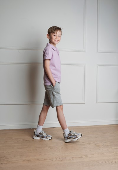 PS Poelman sneakers worn by a boy in a walking pose.
