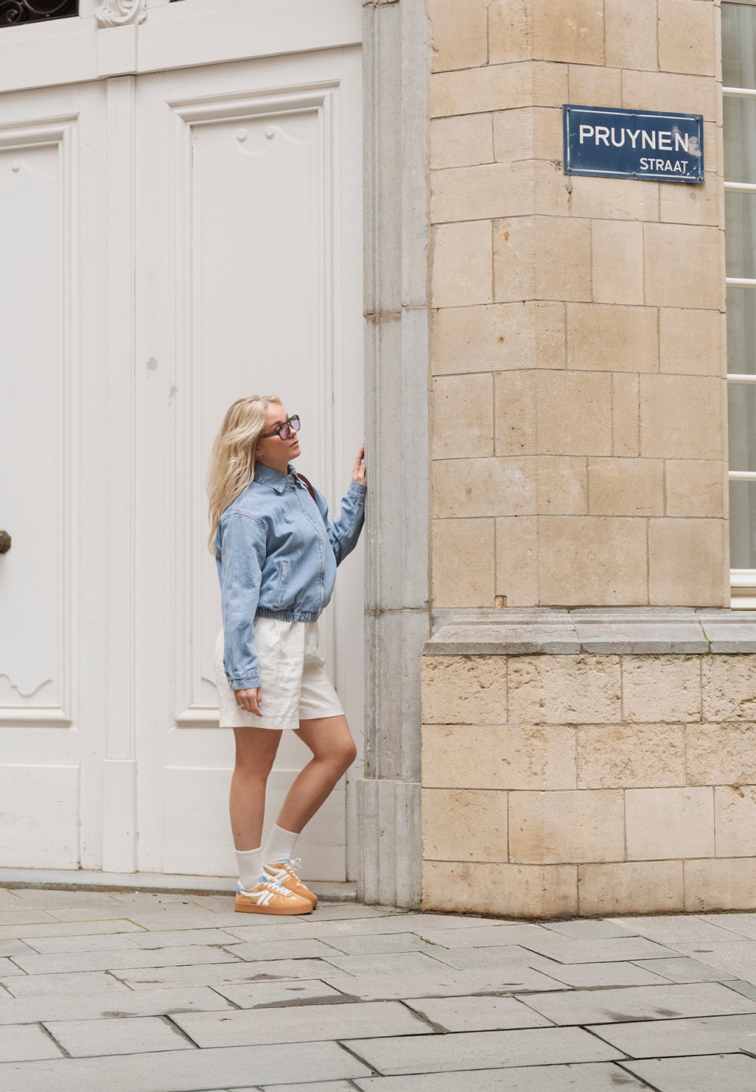 FLO Sneaker von POSH by Poelman, getragen mit einer kurzen Hose und einer Jeansjacke.