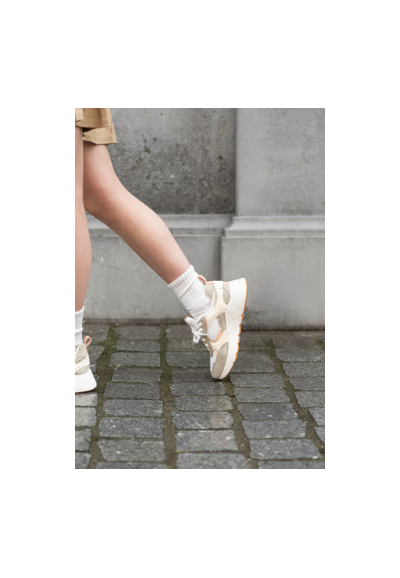 The model is wearing Caro sneakers by POSH by Poelman.