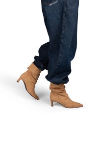 Model trägt POSH By Poelman Laureen sandfarbene Stiefel mit dunkler Jeans – Seitenansicht