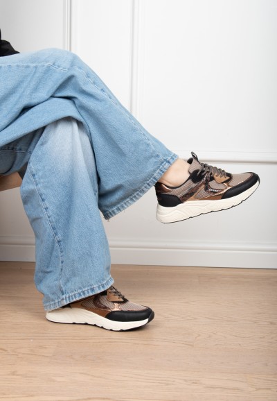 Model draagt POSH By Poelman Kiki zwart beige sneakers met lichte jeans – zittend detail