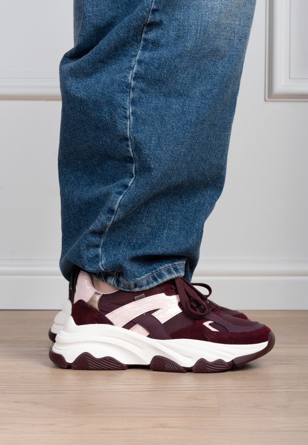 Zijaanzicht van de POSH by Poelman dames sneakers in bordeaux gedragen aan de voet