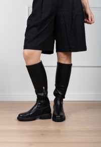 Model trägt POSH By Poelman Jennifer schwarze Stiefel mit schwarzem Kleid – Vorderansicht