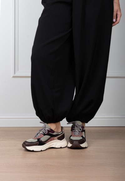Model trägt POSH By Poelman Angy bordeauxfarbene Sneaker mit Animal-Print und schwarzer Hose – Vorderansicht