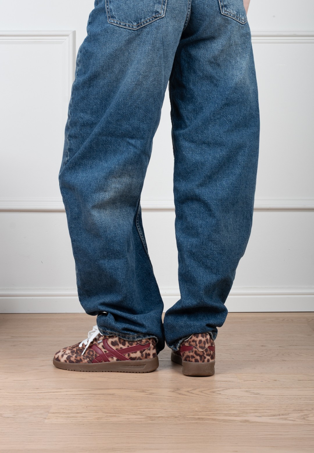 Model draagt POSH By Poelman Megan sneakers met luipaardprint en blauwe jeans – vooraanzicht