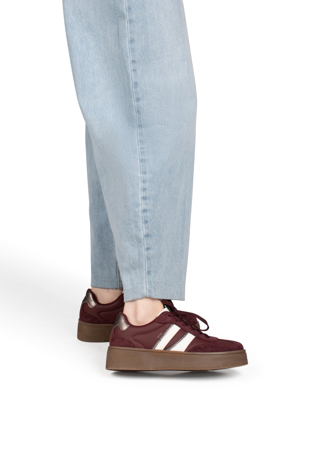 Model trägt POSH By Poelman Lilly bordeauxfarbene Sneaker mit hellblauer Jeans – Seitenansicht