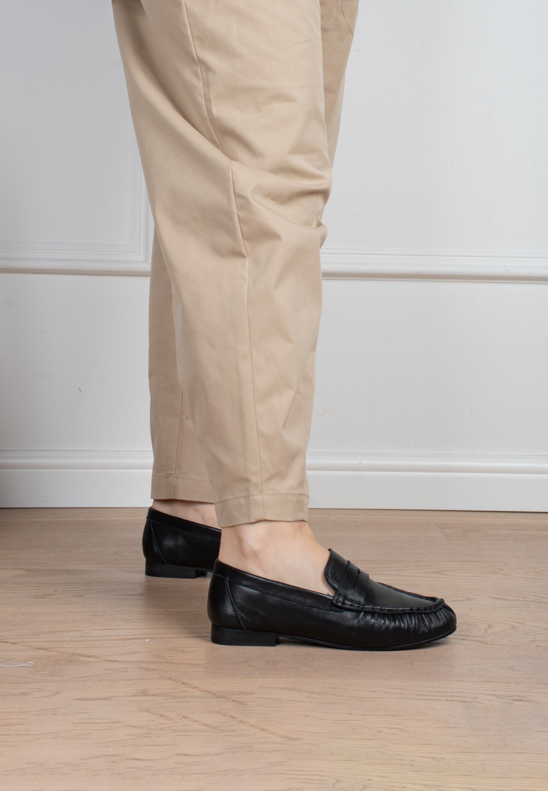 Model trägt Poelman Sammy schwarze Loafer mit beiger Hose – Seitenansicht