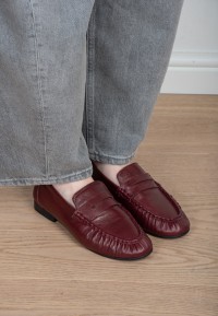Model draagt Poelman Sammy bordeaux loafers met grijze jeans – close-up
