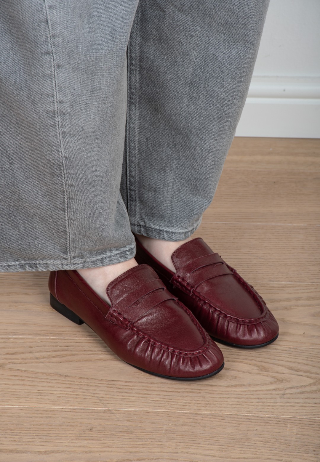 Model trägt Poelman Sammy bordeauxfarbene Loafer mit grauer Jeans – Detailansicht