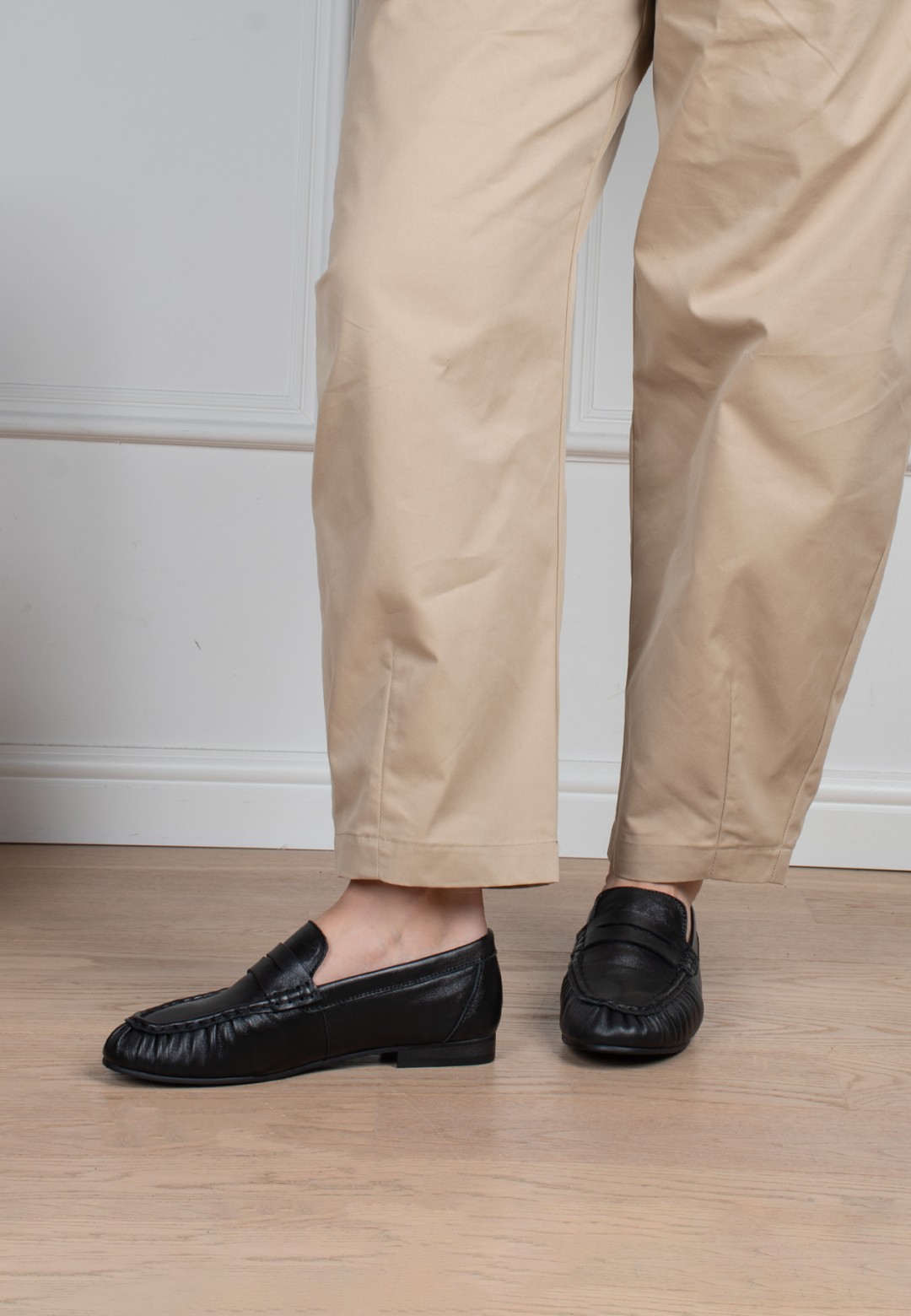 Model trägt Poelman Sammy schwarze Loafer mit beiger Hose – Vorderansicht