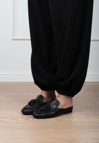 Poelman LOTTIE dames loafers van zwart leer gedragen onder een zwarte broek