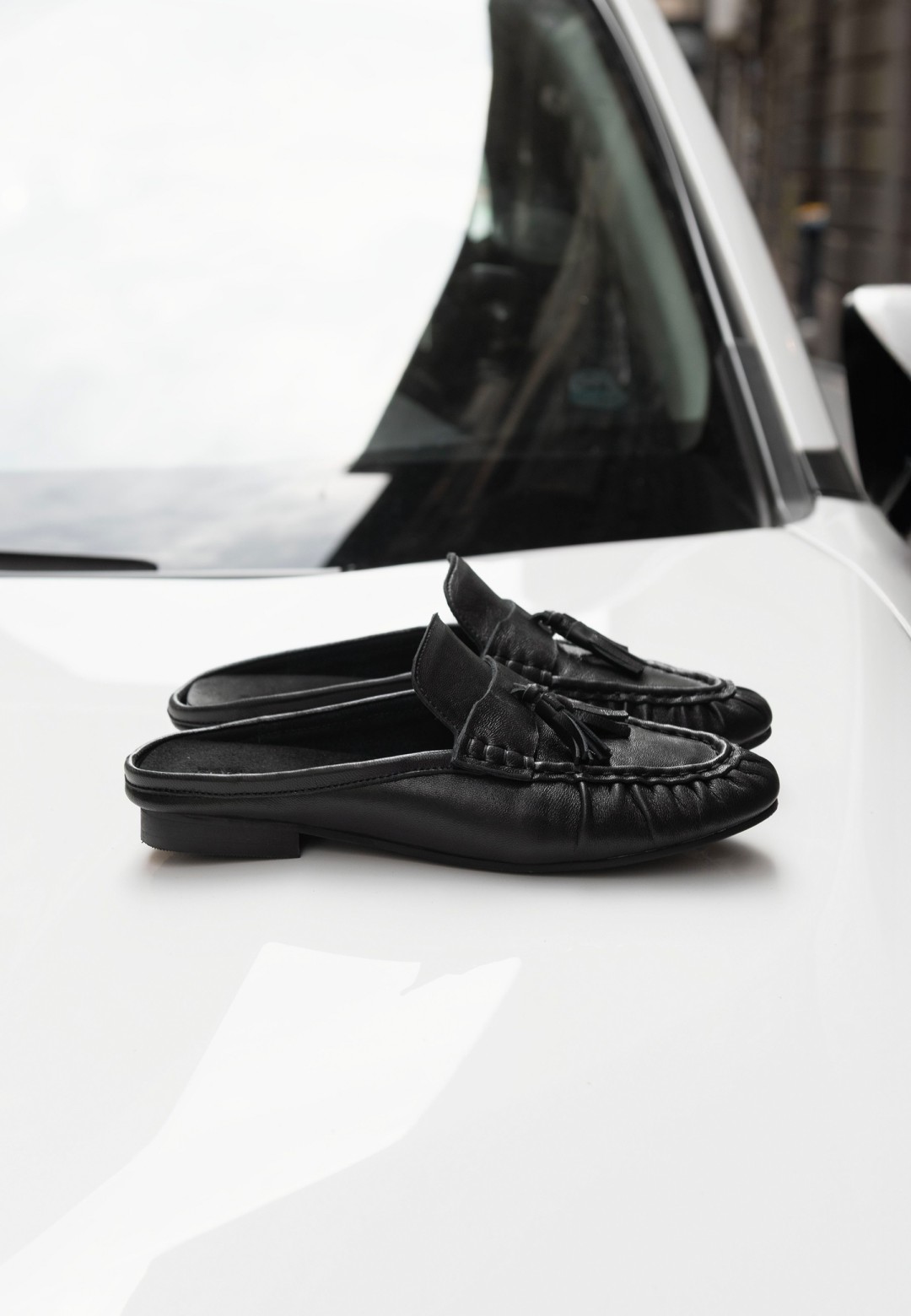 POSH by Poelman LOTTIE black loafers with chunky sole on a white car