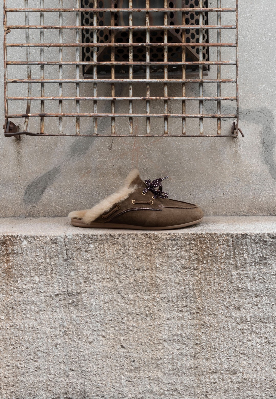 ISA bruine loafers met gespdetail op een stenen rand