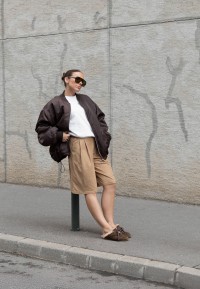 ISA bruine loafers gedragen met een beige pantalon en zwarte jas
