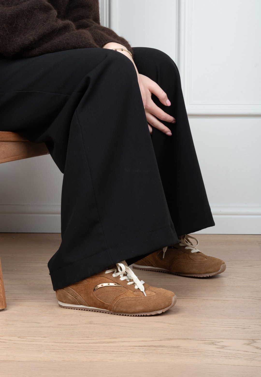 Poelman TAMARA dunkelbeige Wildleder Sneaker kombiniert mit schwarzer Hose im Sitzen